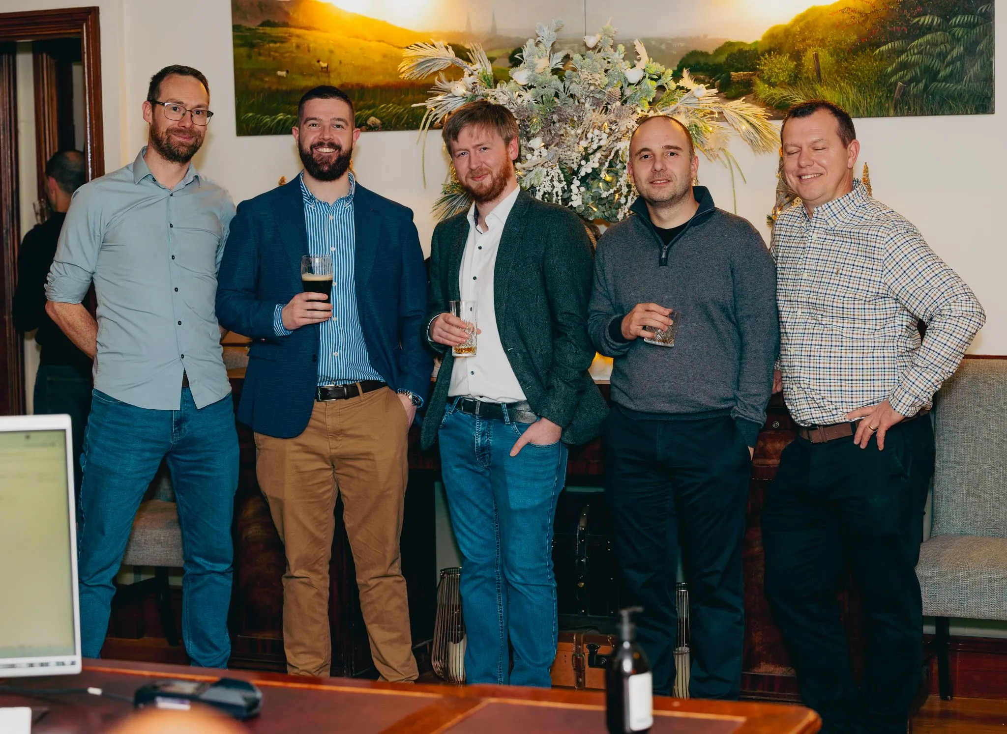 Group of five men at Eagle event enjoying drinks.