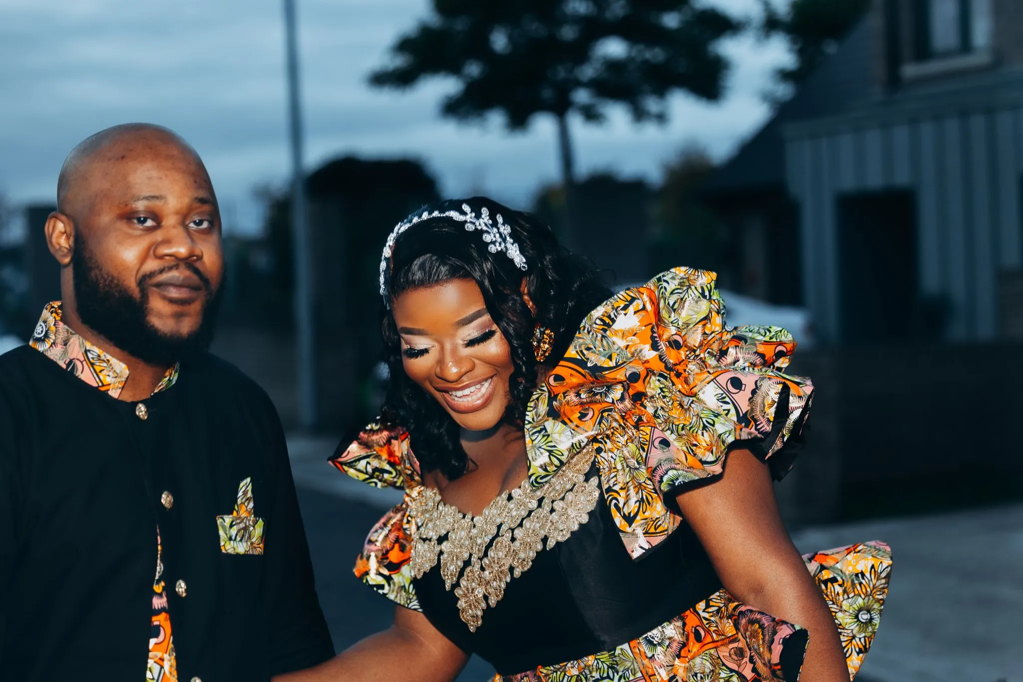Couple in vibrant African fashion smiling outdoors