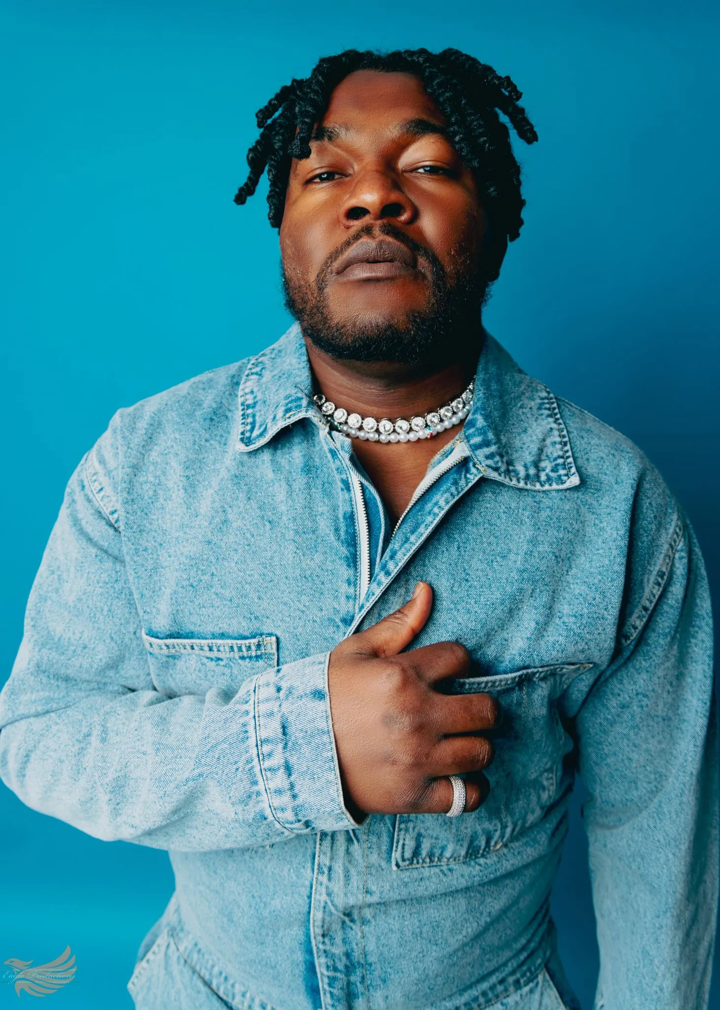 Person wearing a denim jacket against a blue background