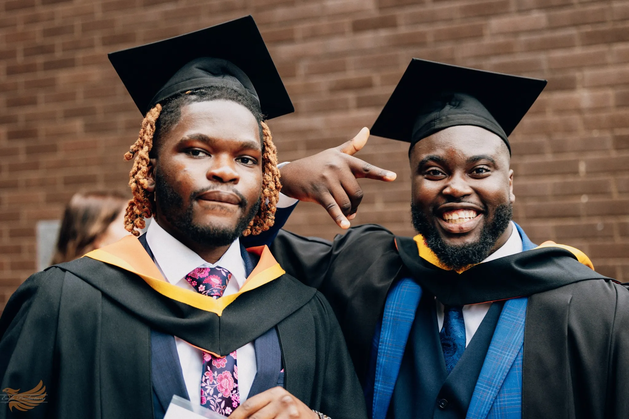 Eagle Productions Graduation Two Men Caps Gowns Outdoor