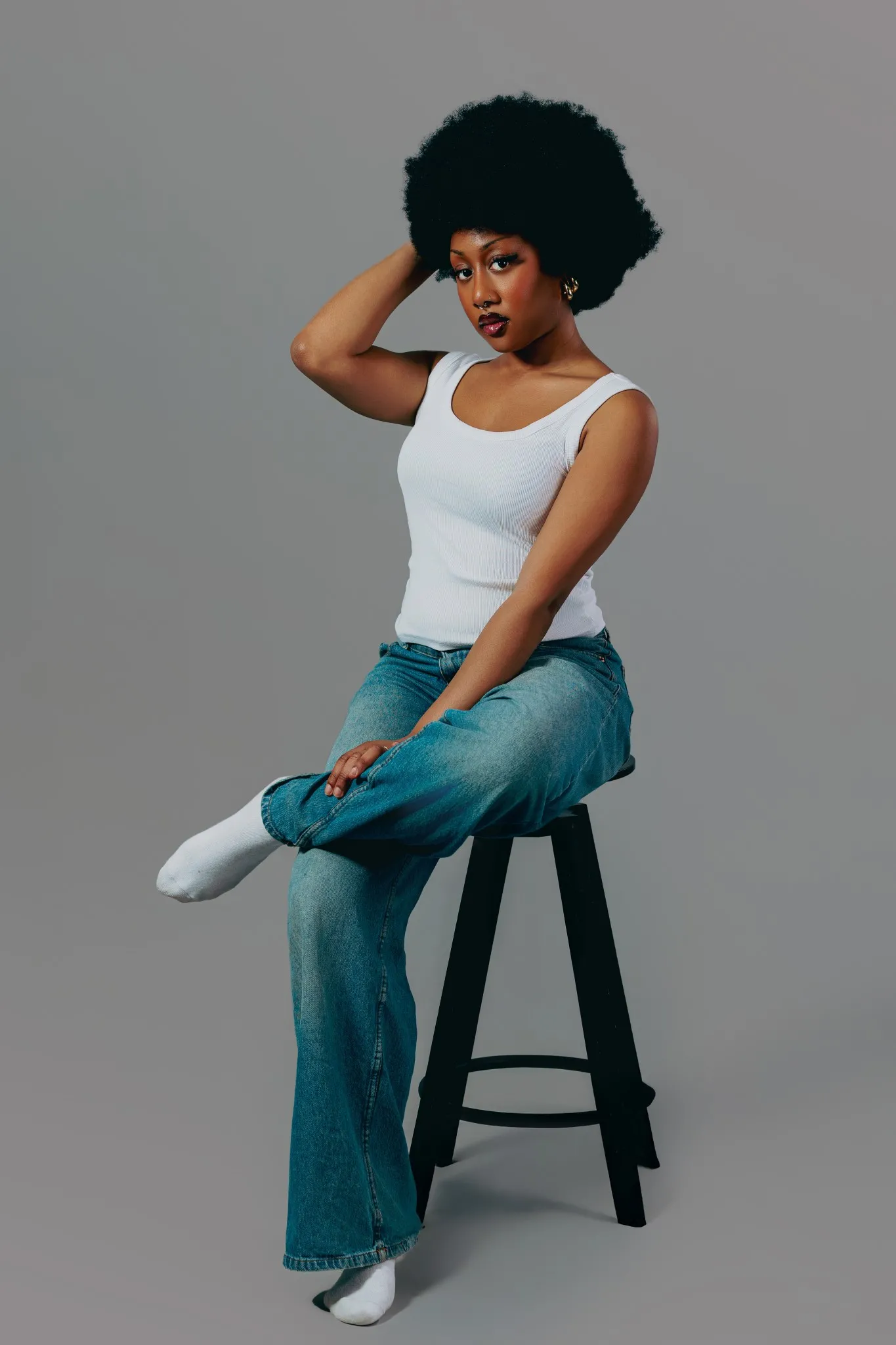 Eagle Productions Portraits Woman Afro White Top Jeans Stool