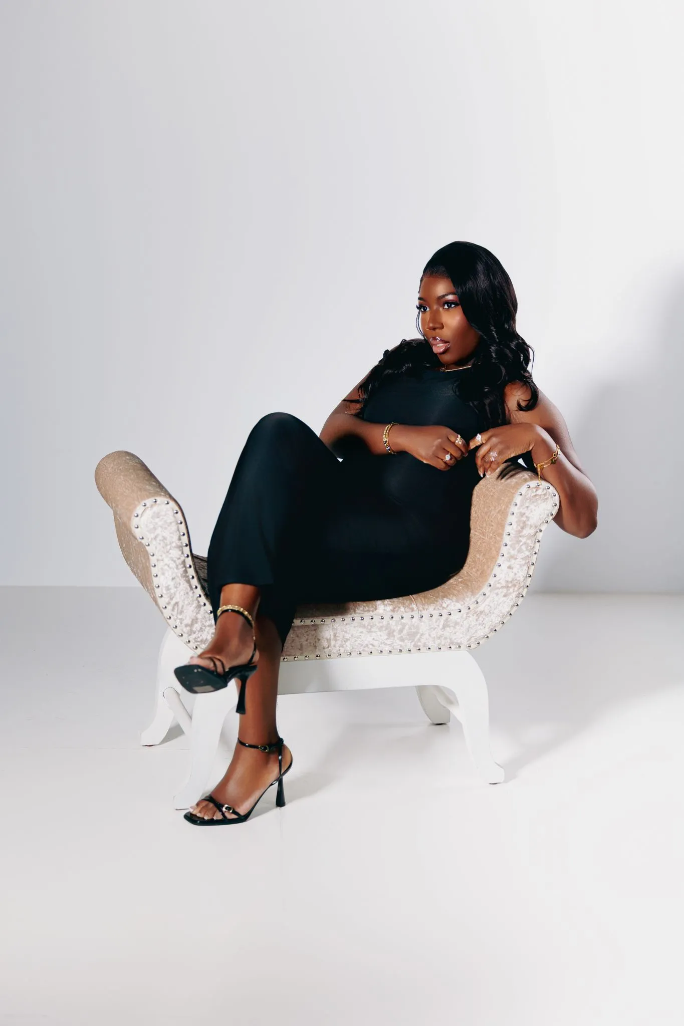 Elegant woman in black dress posing on a stylish chair