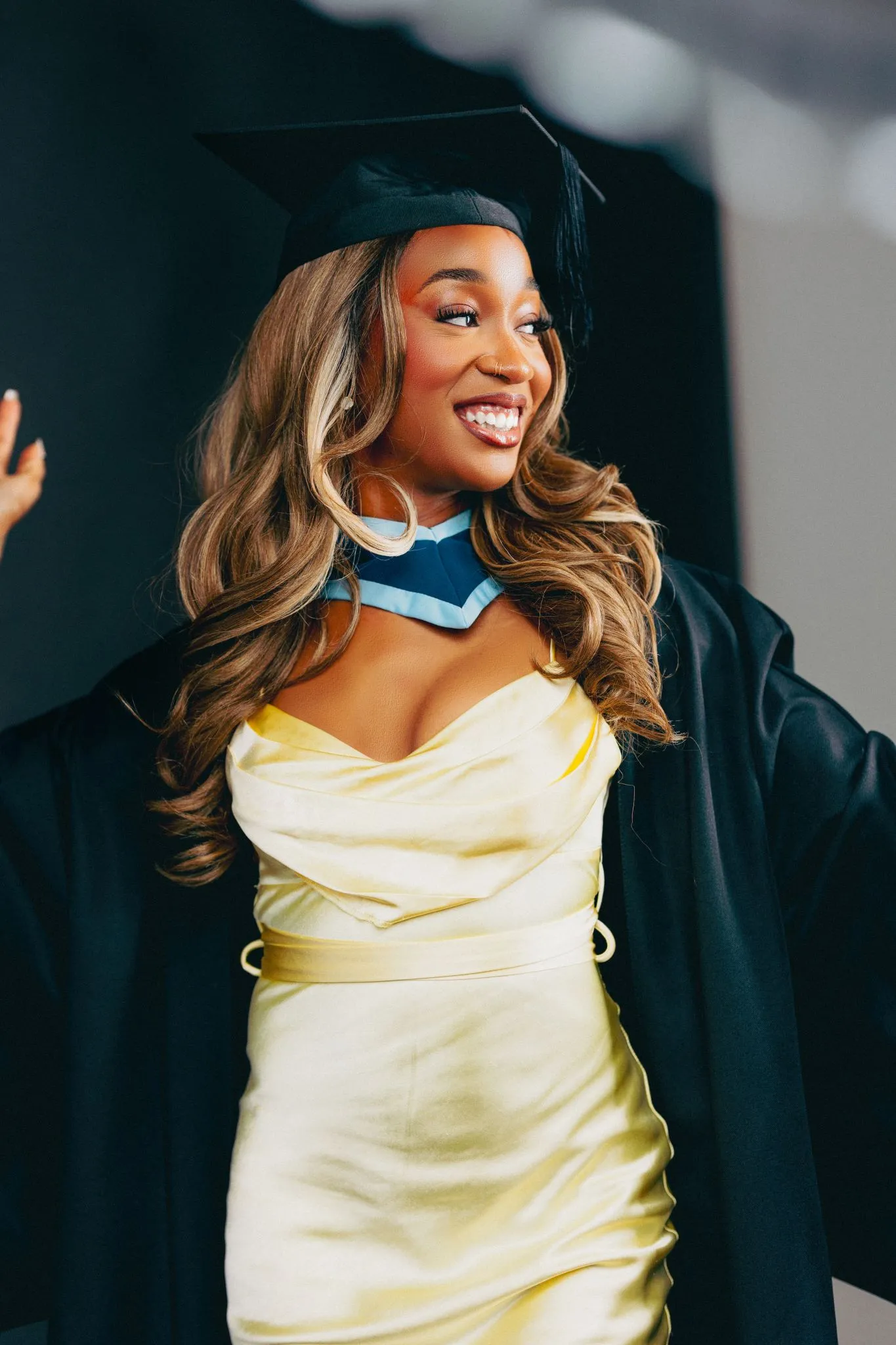 Graduate smiling in cap and gown at Eagle celebration