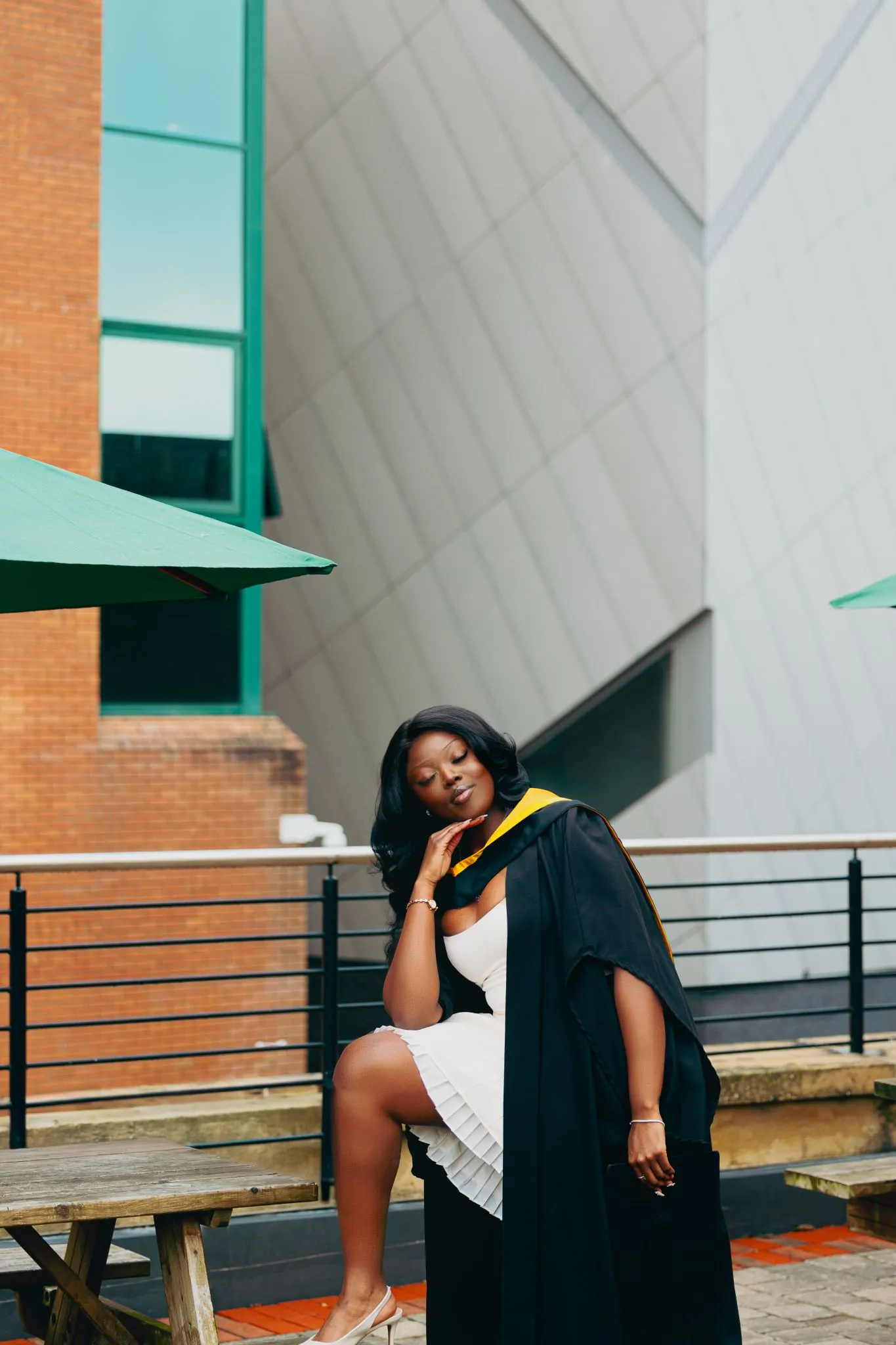 Graduate in cap and gown posing outdoors at Eagle campus.