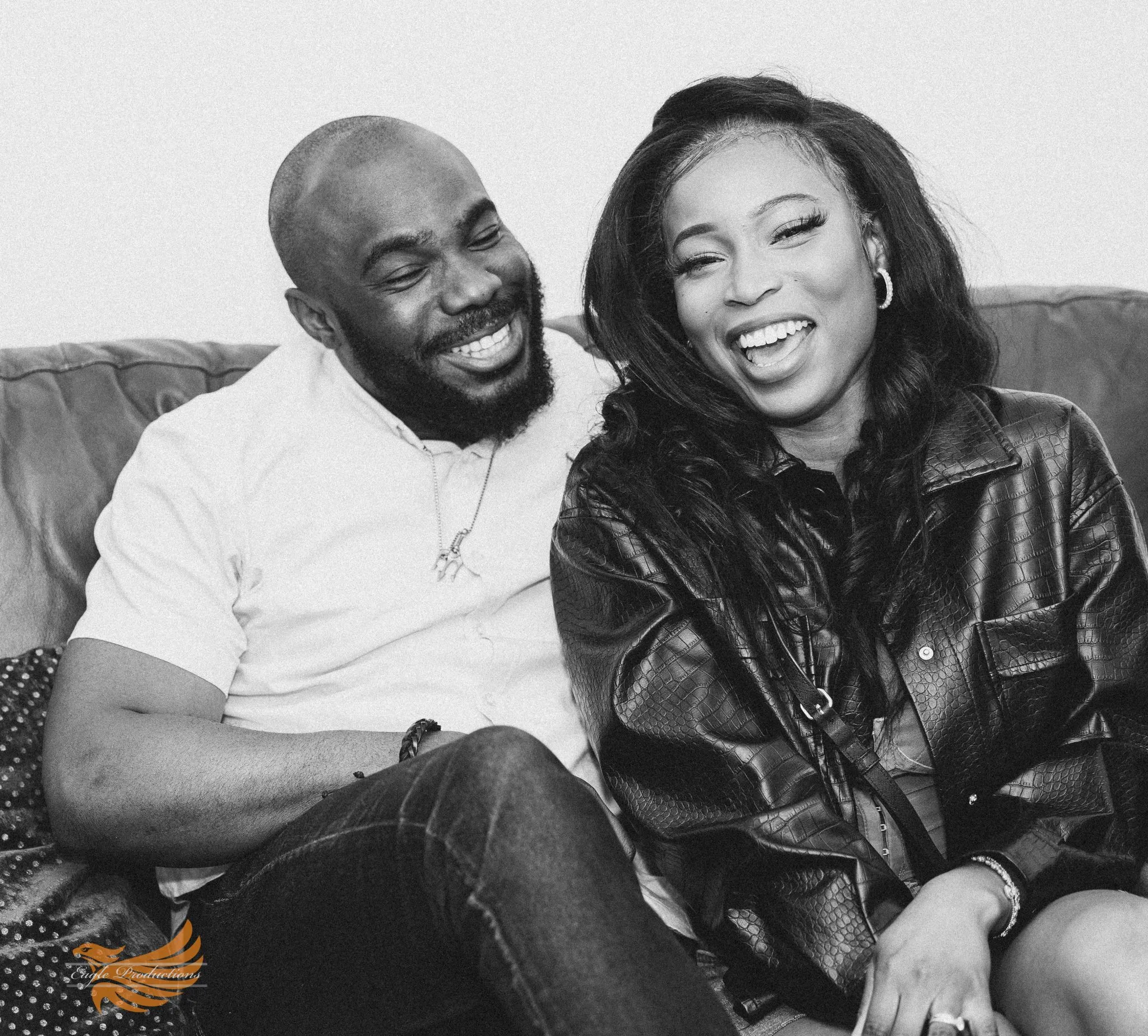 Happy couple laughing together on a couch