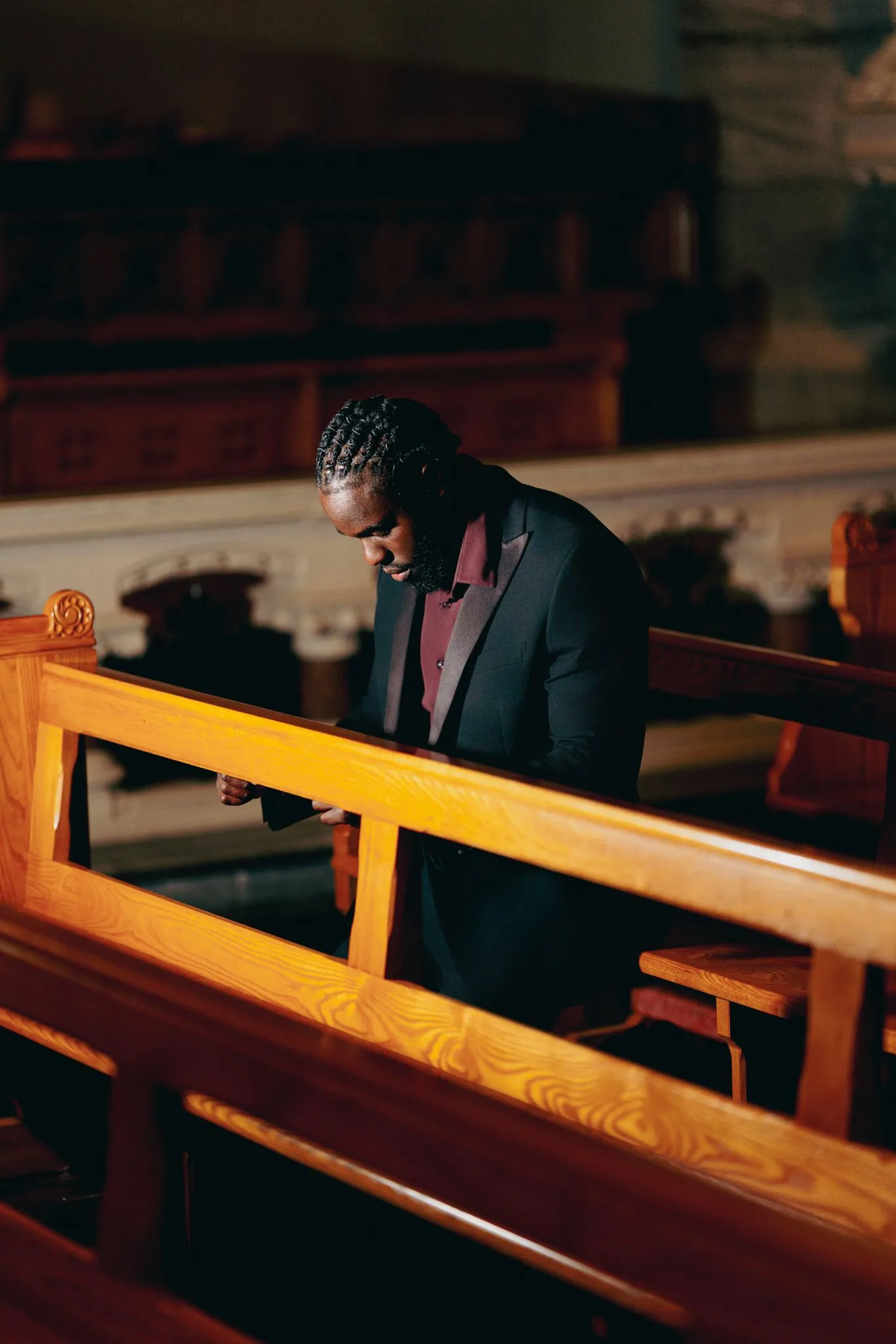 Man praying in a church pew, deep in thought.