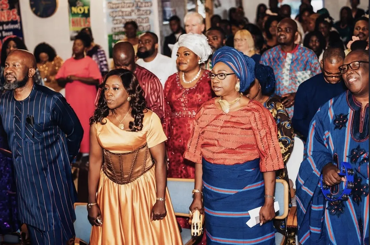 Group of people in vibrant Nigerian traditional attire at an event.