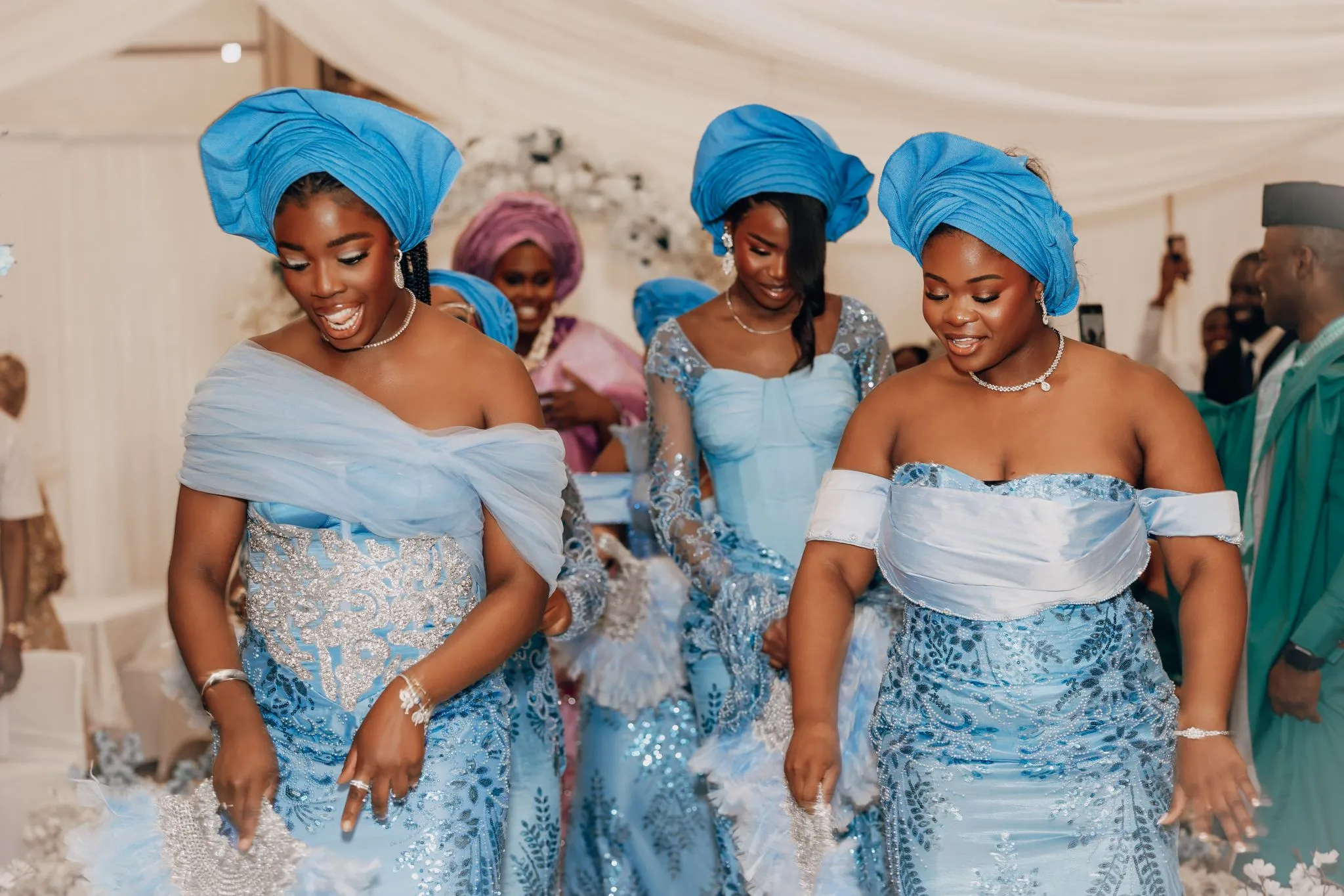 Nigerian women in traditional blue attire dancing joyfully