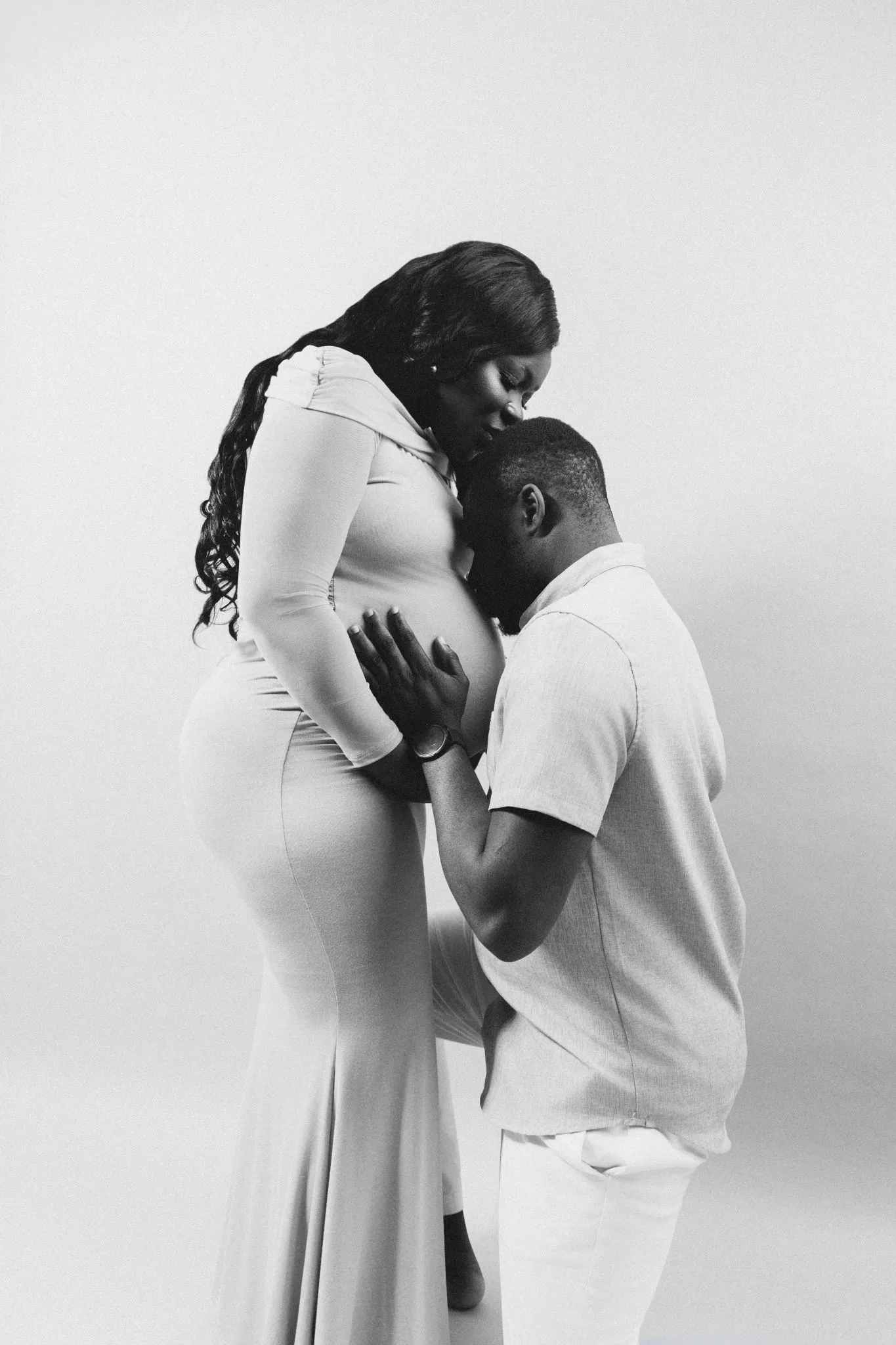 Pregnant couple sharing a tender moment, embracing love and anticipation.