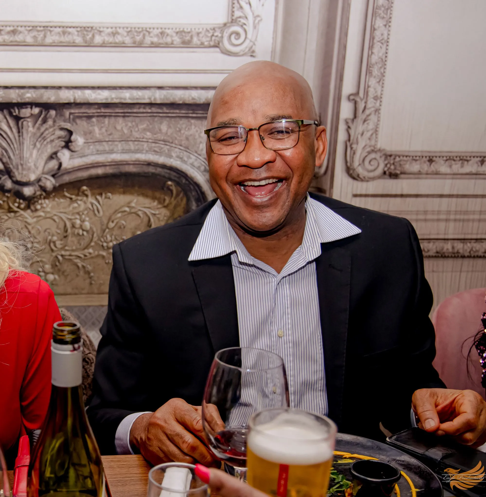 Smiling man dining with drinks and food at a restaurant