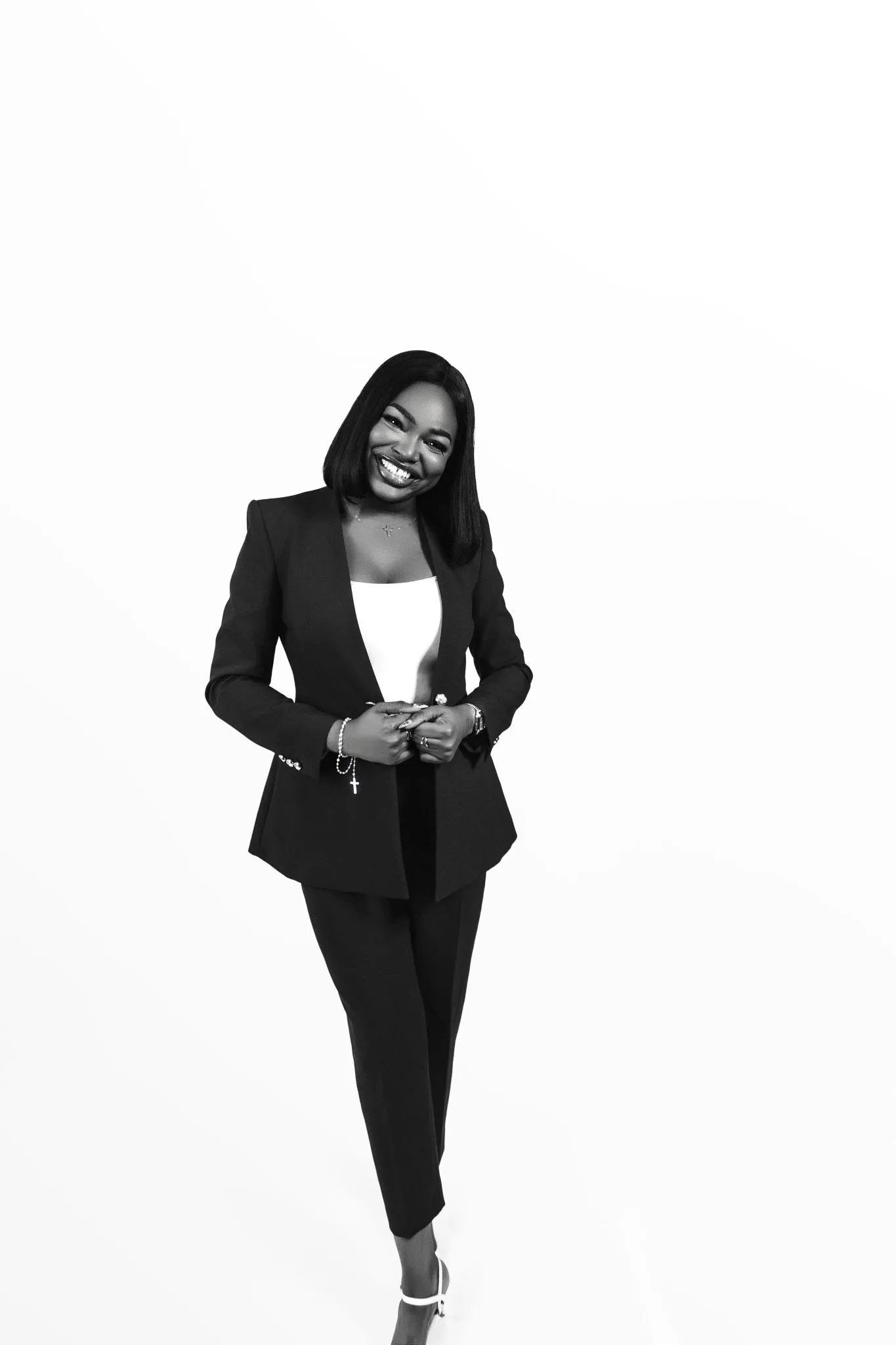 Smiling professional woman in a suit, standing confidently.