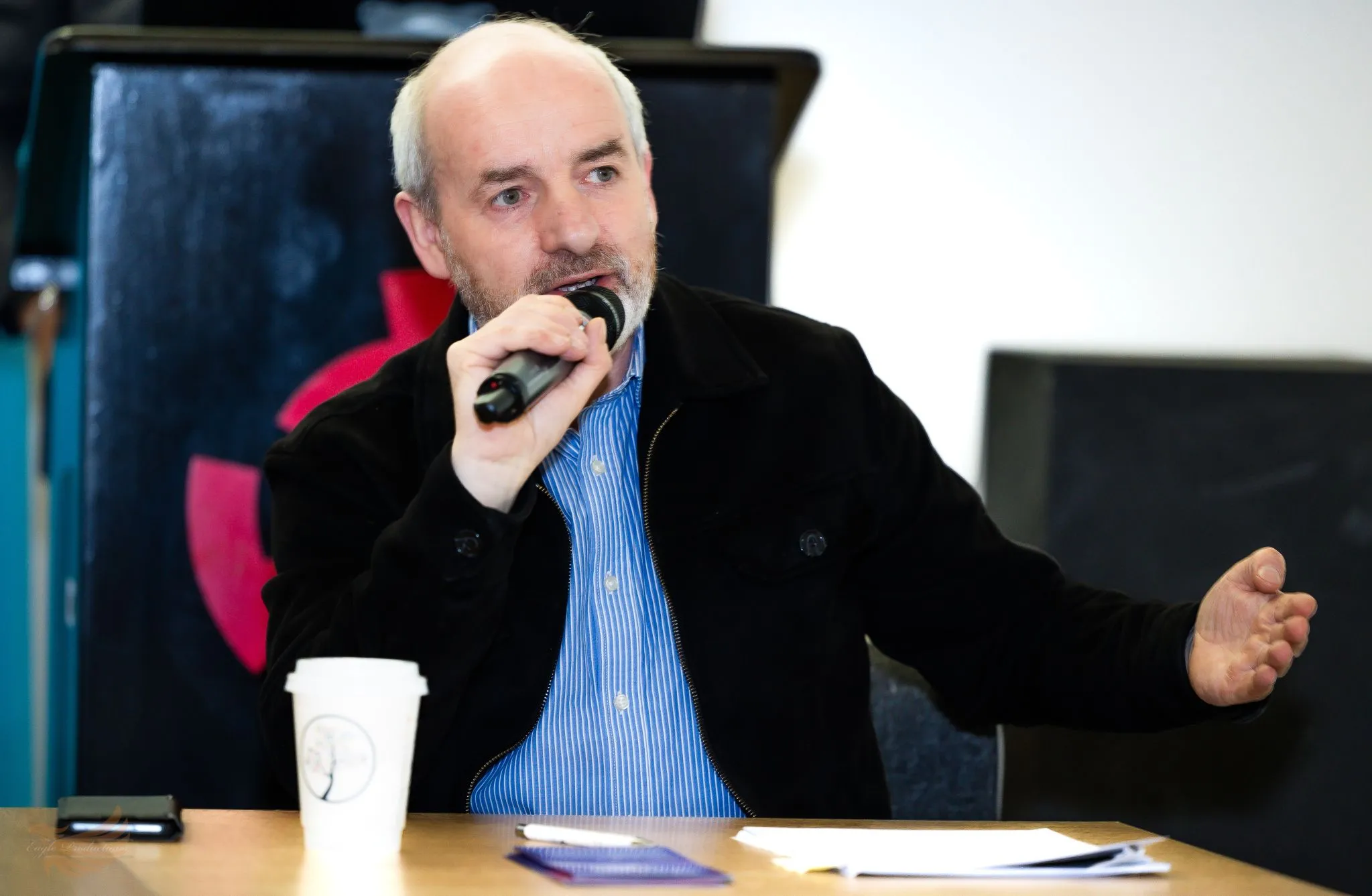 Speaker at Eagle conference discussing key topics with microphone.