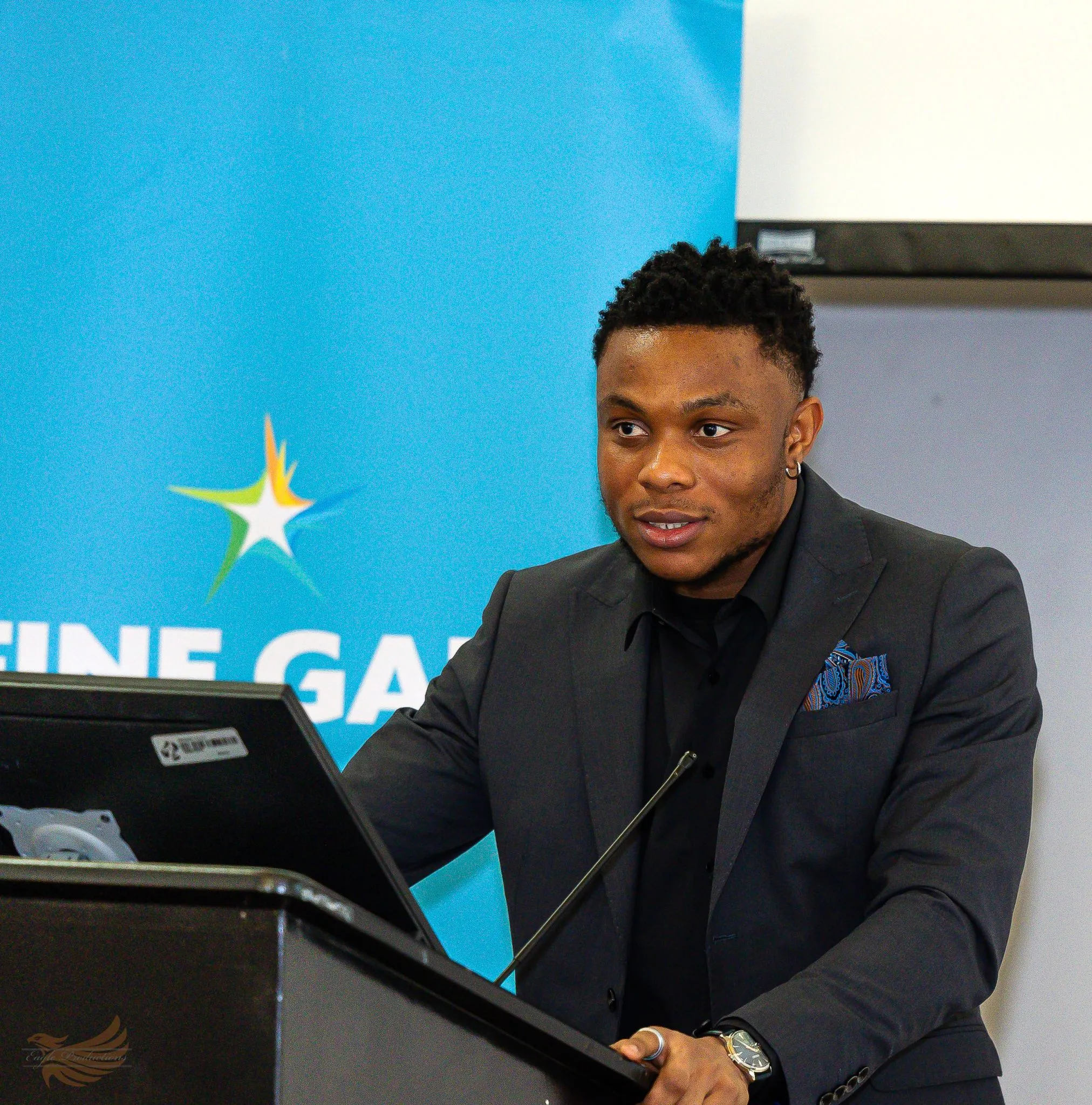 Speaker at podium during Eagle event, presenting confidently.