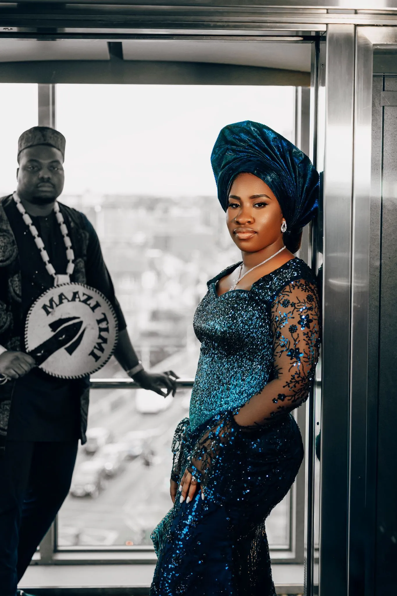 Man and woman in traditional Nigerian attire with blue and black designs.