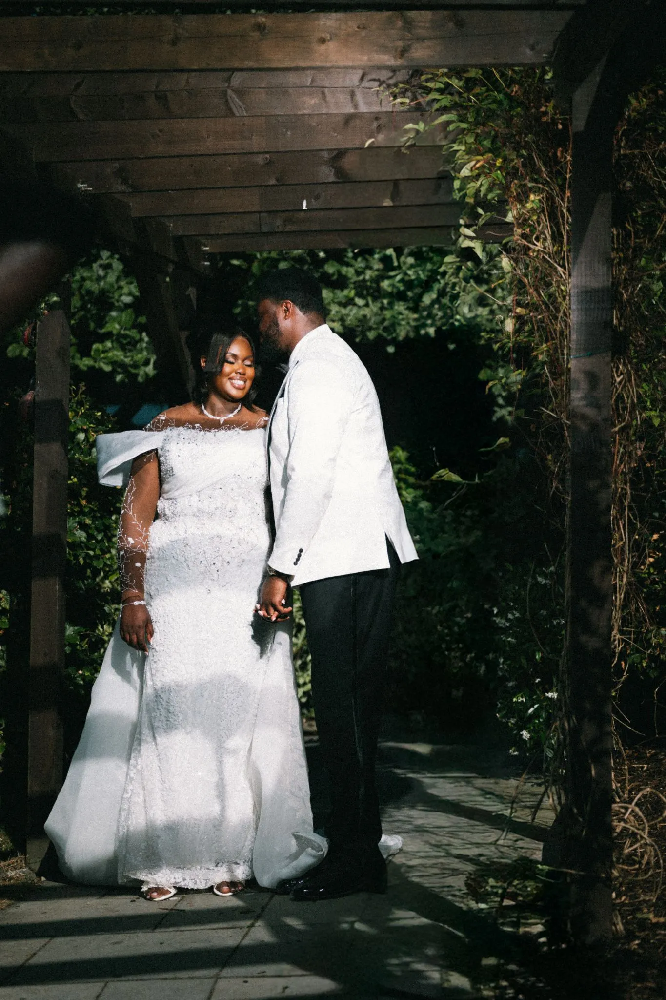 Wedding couple in a garden under a wooden archway
