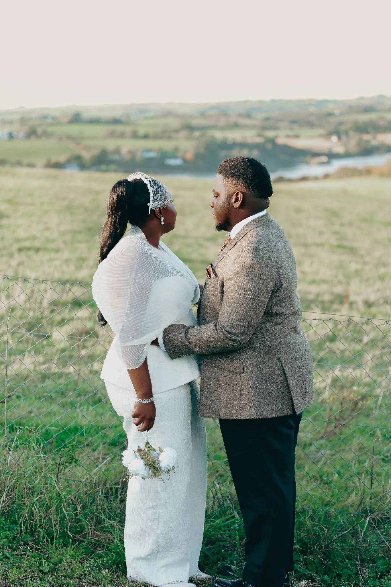 Wedding couple embracing outdoors with scenic landscape
