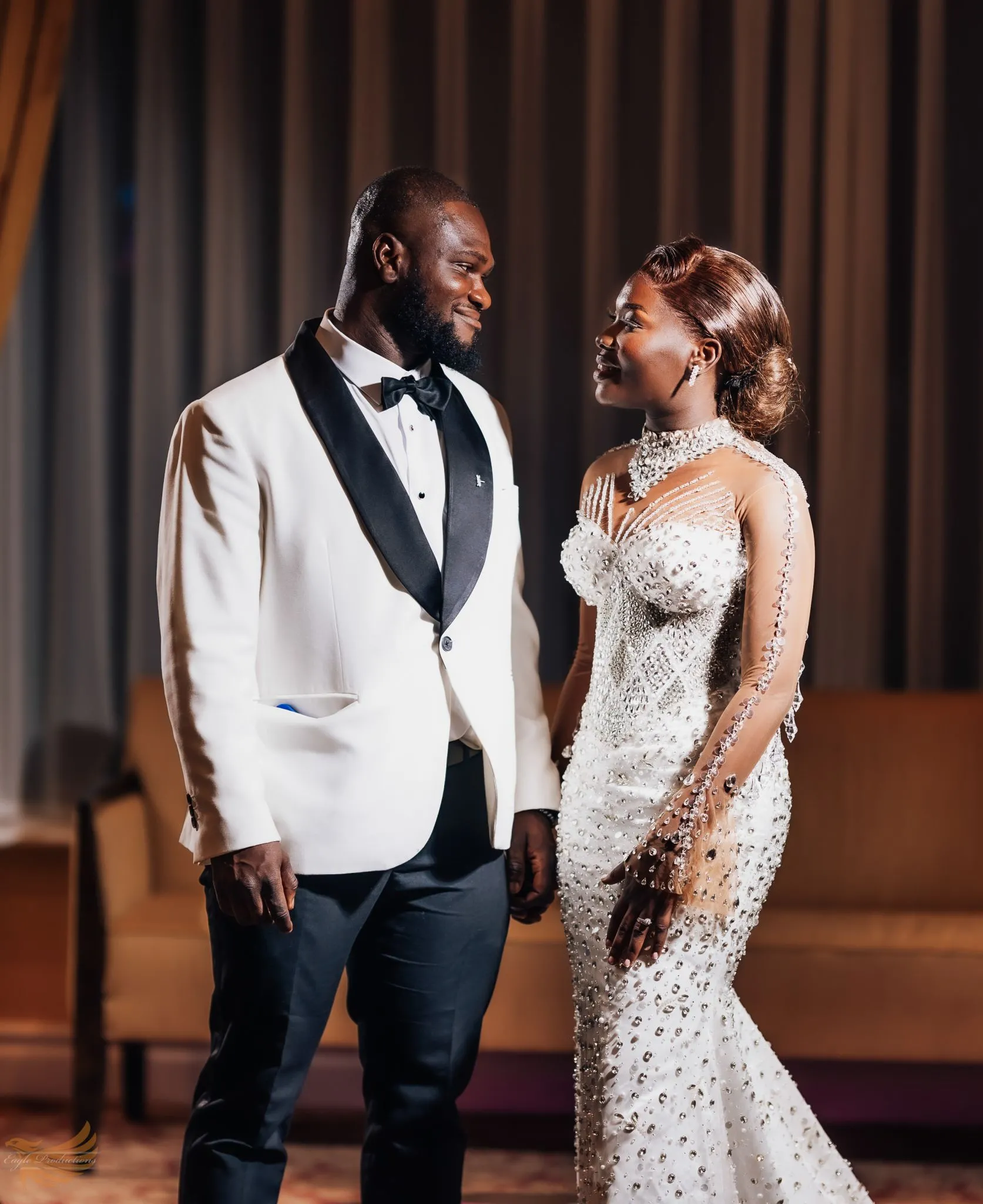 Smiling wedding couple in elegant attire at Eagle venue