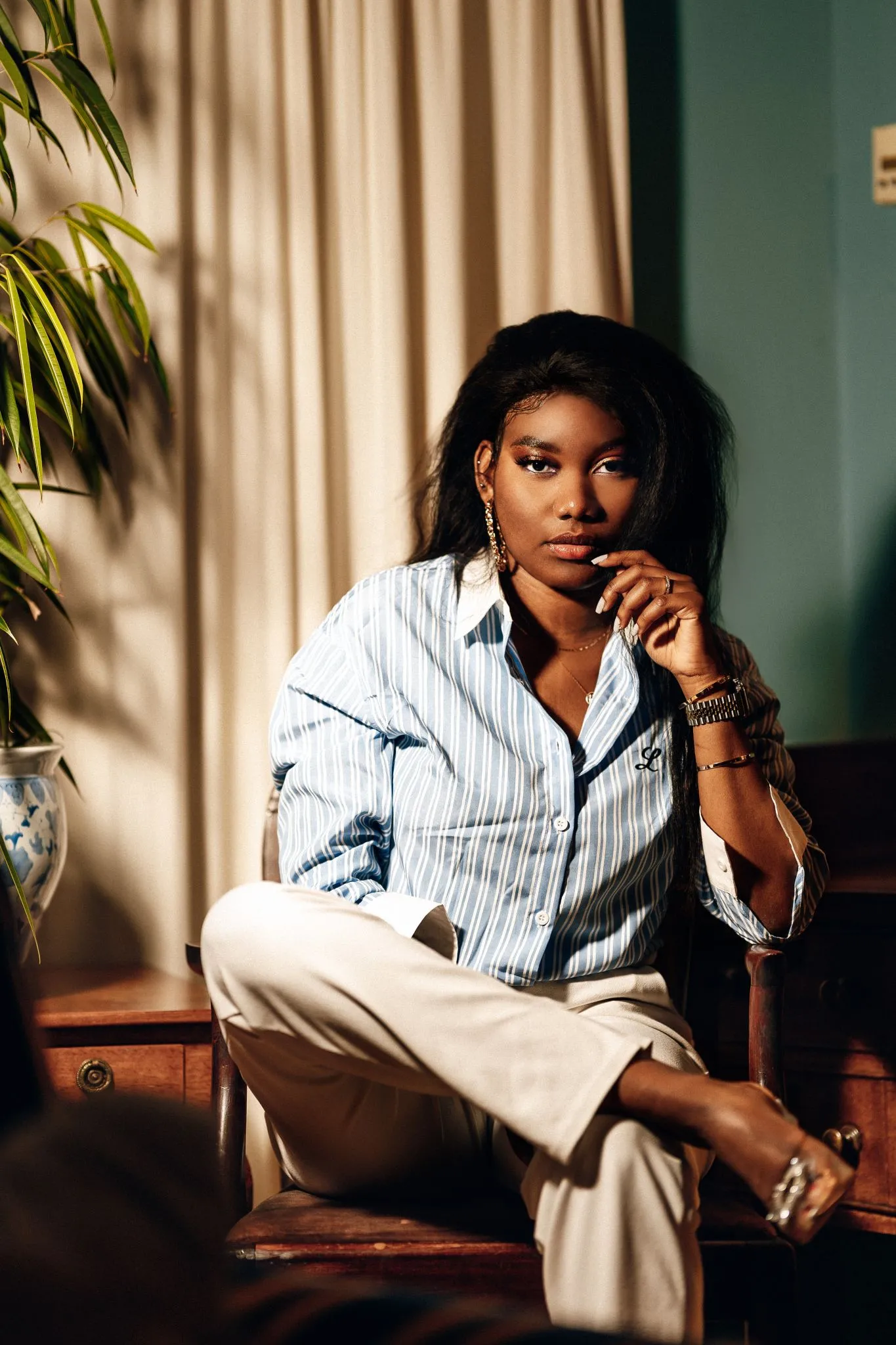 Woman in a contemplative pose sitting in a stylish room
