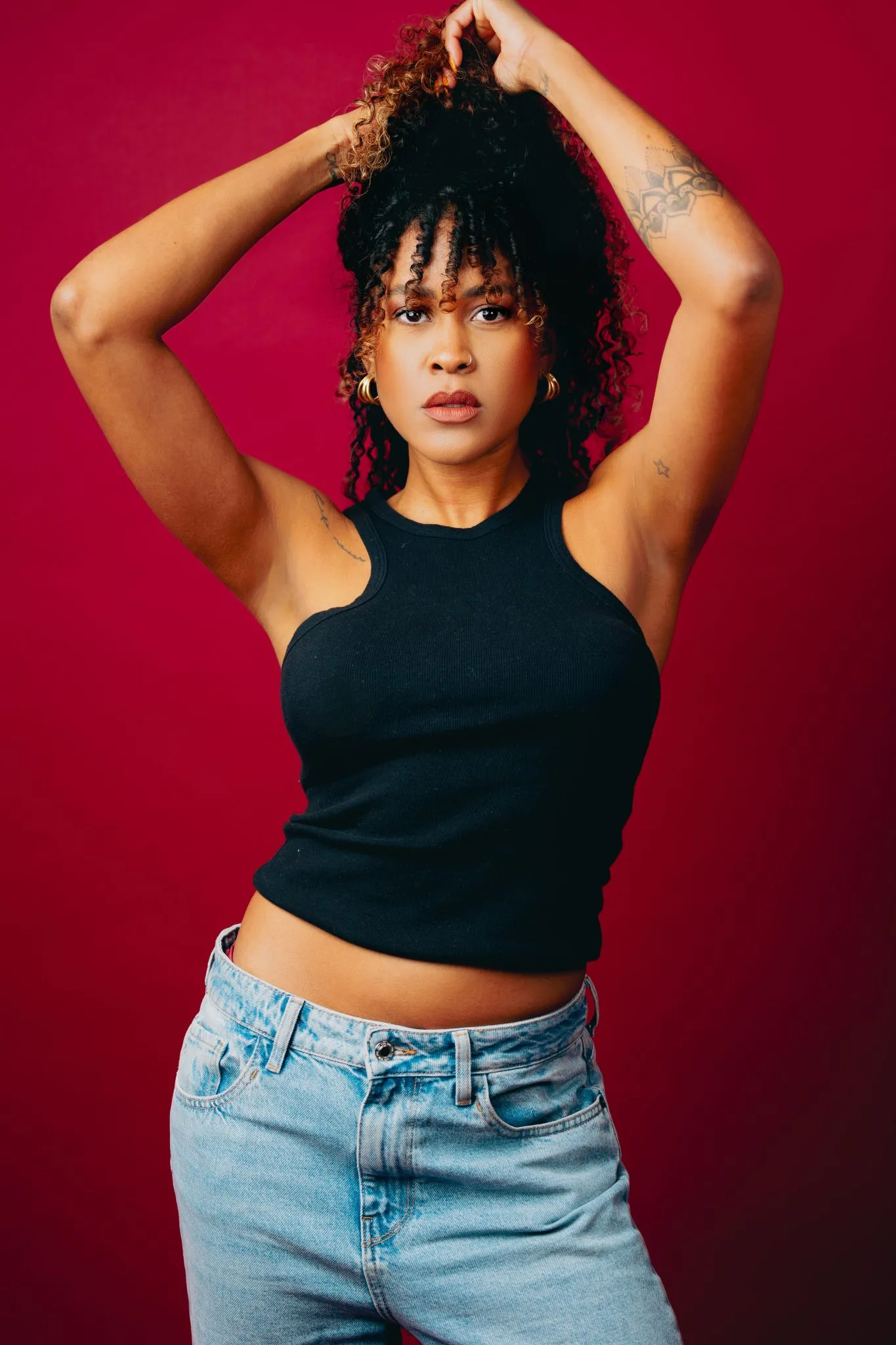 Woman posing confidently against a red background