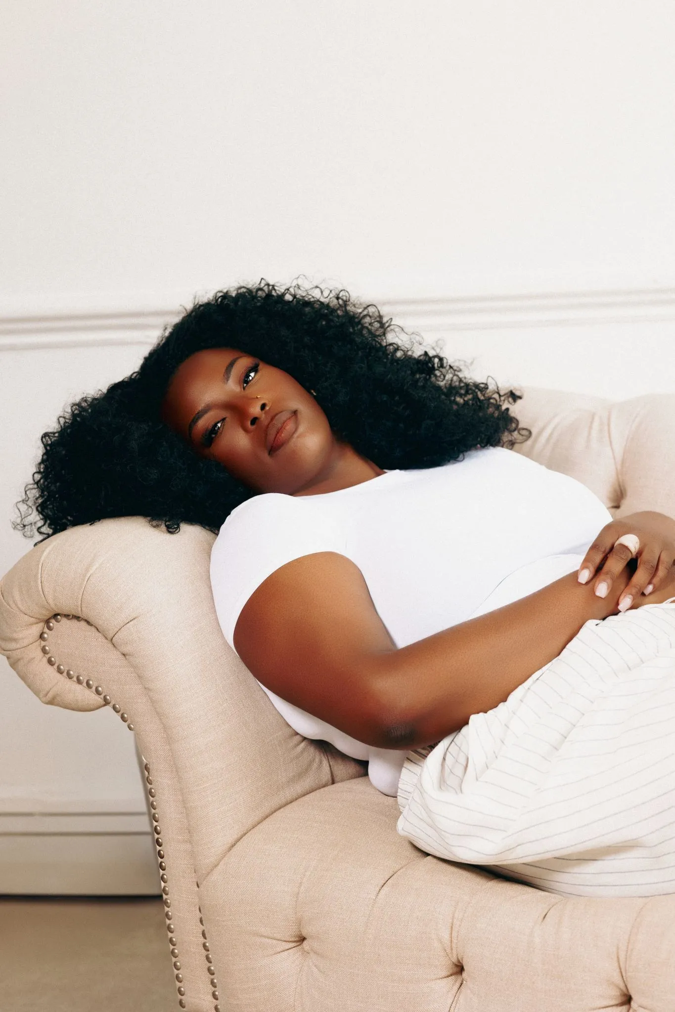 Woman relaxing on a sofa in a bright room with large window