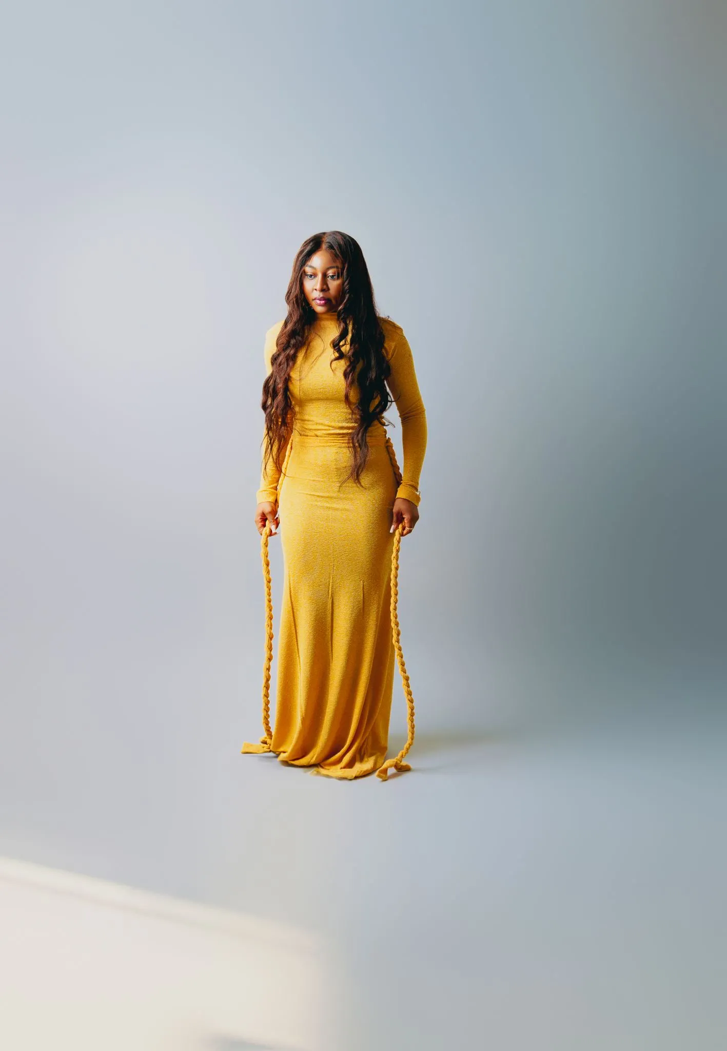 Woman in a long yellow dress standing gracefully